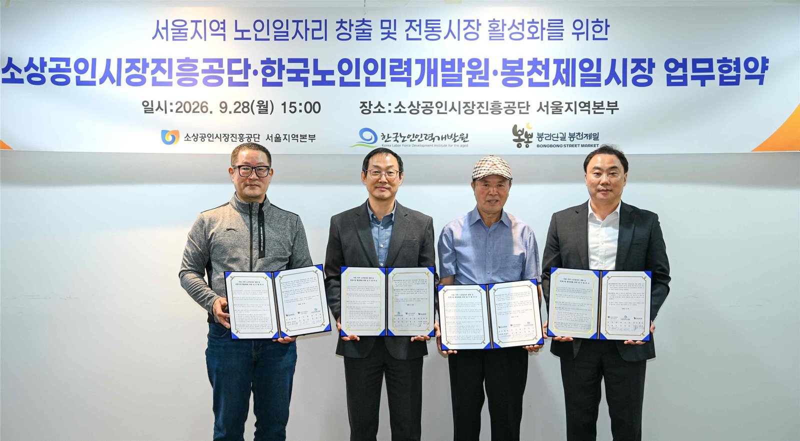 봉천제일시장 노인일자리 업무협약식에서 기관 대표들이 협약서를 들고 기념촬영을 하고 있다