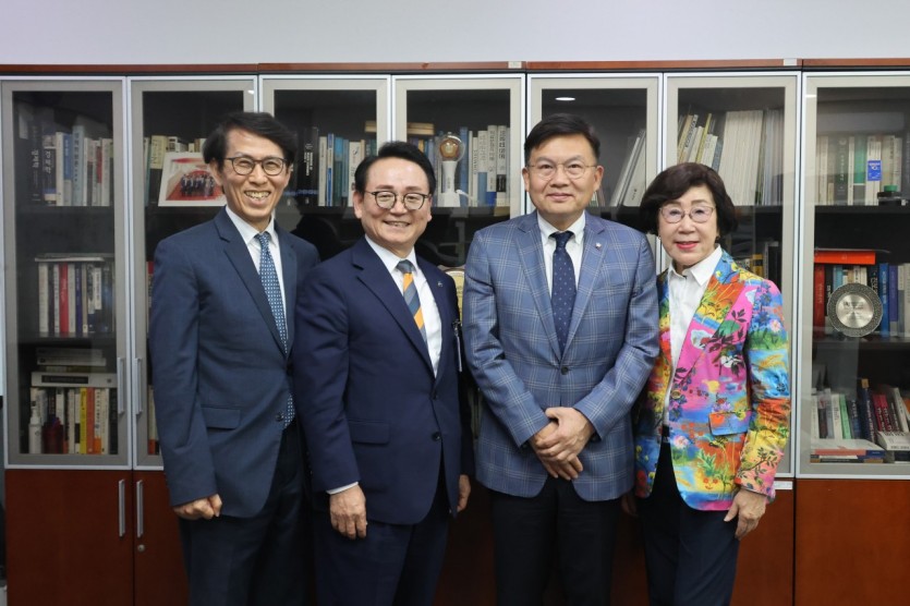 국회 의원실 책장 앞에서 한국노인복지중앙회 관계자와 국회의원 등 네 사람이 나란히 서서 기념사진을 찍고 있다