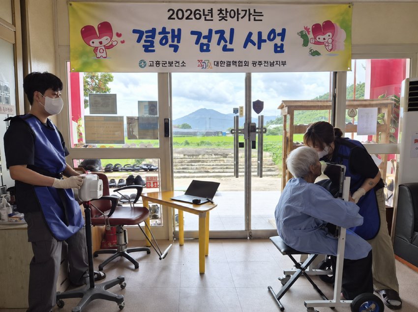 경로당 이동검진 현장에서 어르신이 의료진의 안내를 받고 있다